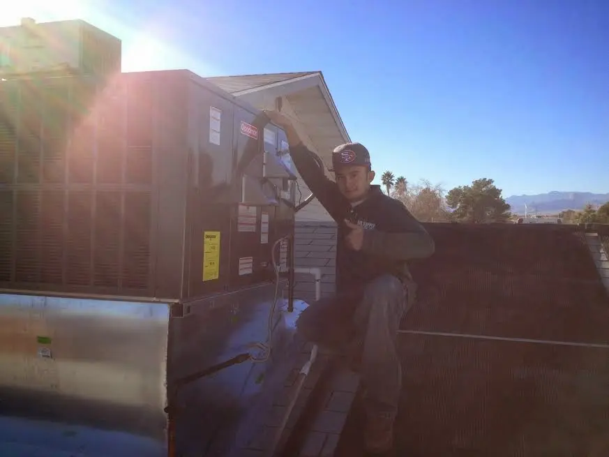 HVAC technician performing Air Duct Cleaning on a rooftop unit in Breckenridge